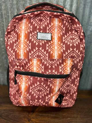 Backpack with geometric pattern and visible brand label on a wooden surface.