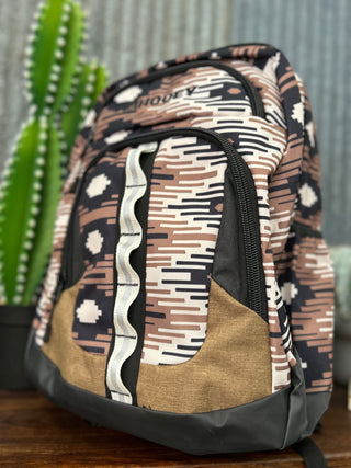 Patterned backpack on a wooden surface with a cactus in the background
