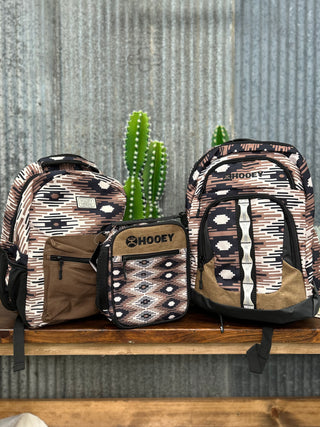 Three patterned bags on a wooden surface with a cactus plant in the background.