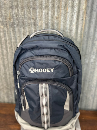 Navy blue backpack with 'Hooey' logo on a textured surface
