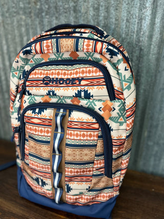Backpack with tribal pattern and 'Shooey' branding on a wooden surface.