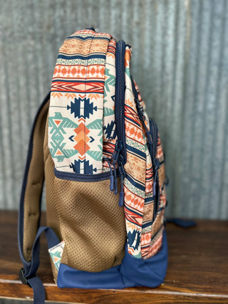 Backpack with tribal pattern on a wooden surface and metal wall background