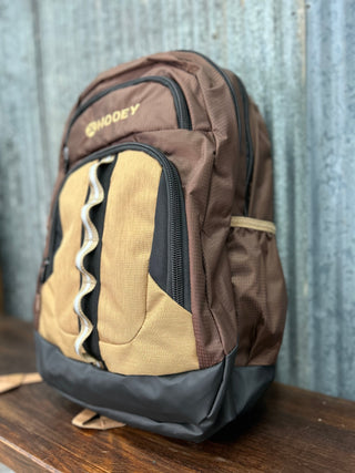 Brown and beige backpack with a visible brand logo on a wooden surface.