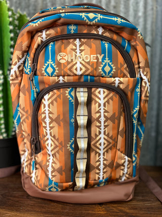 Backpack with tribal pattern and 'Hooey' branding on a wooden surface.