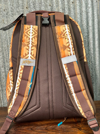 Brown saddle pad with patterned straps on a wooden surface