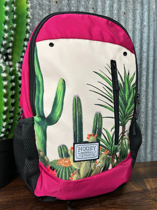 Backpack with cactus design and pink border on a metal surface