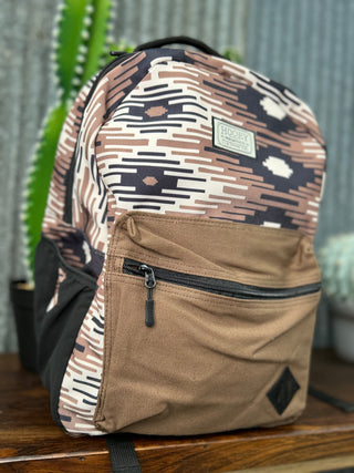 Camouflage-patterned backpack with a visible brand label on a wooden surface.