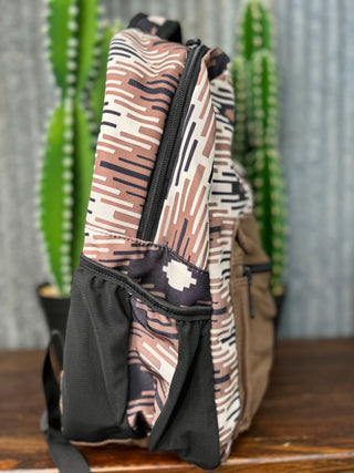 Backpack with a patterned design on a wooden surface with cacti in the background