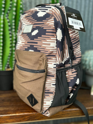 Camouflage-patterned backpack with a visible brand tag on a wooden surface.