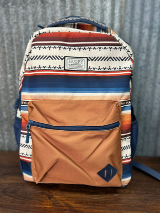 Backpack with tribal pattern and brown pocket on a wooden surface