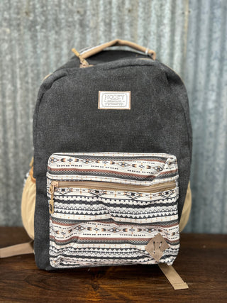 Gray backpack with a patterned front pocket on a wooden surface