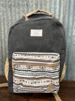 Gray backpack with a patterned front pocket on a wooden surface.
