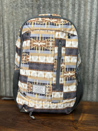 Patterned backpack on a wooden surface with a gray textured background