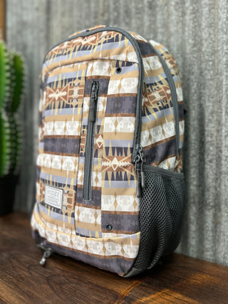 Patterned backpack on a wooden surface with a textured wall background