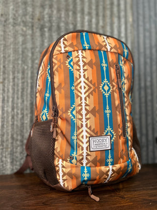 Backpack with tribal pattern on a wooden surface and textured wall background