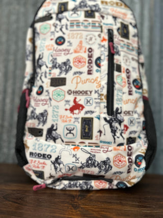 Backpack with a pattern of logos and text on a wooden surface