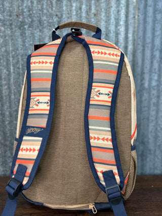 Backpack with a patterned design on a wooden surface and metal wall background