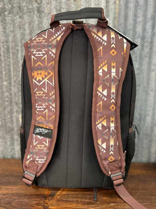 Backpack with patterned straps on a wooden surface and rustic background
