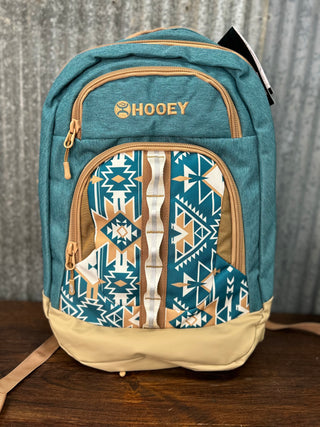 Blue backpack with geometric pattern and 'Hooey' branding on a wooden surface.