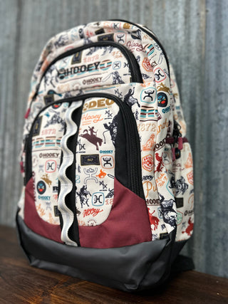 Backpack with multiple logos on a wooden surface and metal wall background