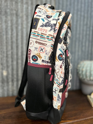 Backpack with colorful patterns and brand logos on a wooden surface.