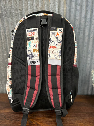 Backpack with patterned back panel on a wooden surface and metal wall background