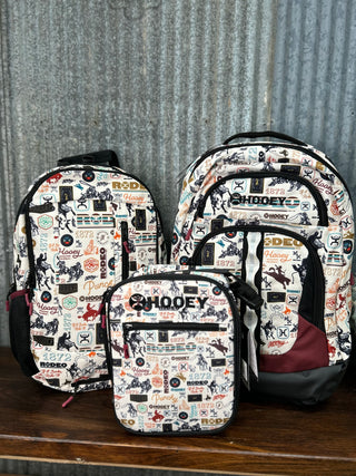 Set of three backpacks with a patterned design on a wooden surface.