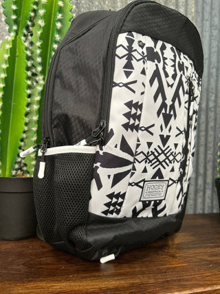 Black and white patterned backpack on a wooden surface with a blurred background