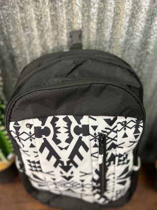 Black backpack with white geometric pattern on a textured surface