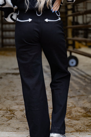 Person wearing black pants with white arrow designs on a blurred background