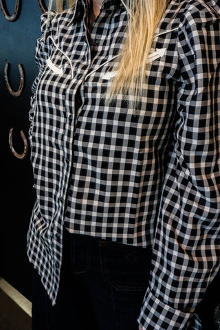 Black and white checkered shirt worn by a person with a blurred background