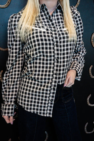 Person wearing a black and white checkered shirt against a dark background
