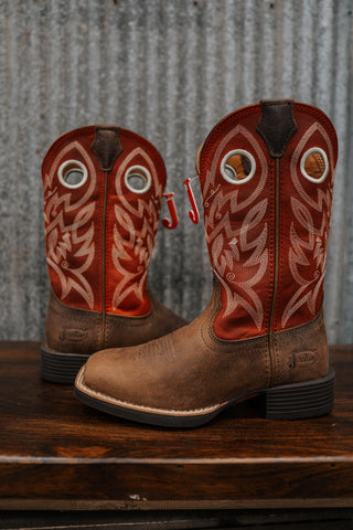Pair of brown cowboy boots with red and white embroidery on a wooden surface.
