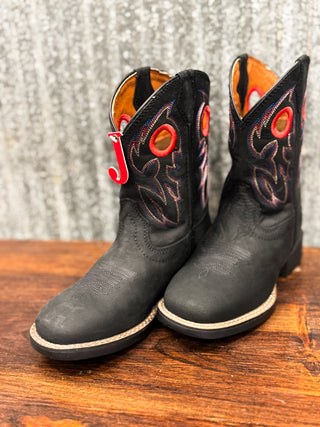 Black cowboy boots with red accents on a wooden surface