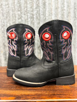Black cowboy boots with red accents on a wooden surface and textured gray background