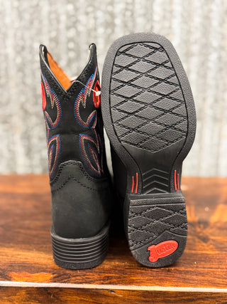 Black cowboy boots with red accents on a wooden surface