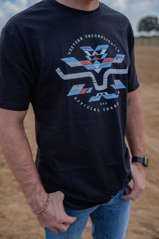 Person wearing a black t-shirt with a blue and red graphic design outdoors.