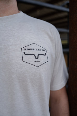 Person wearing a light gray t-shirt with 'Kimes Ranch' logo.
