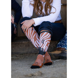 Person wearing patterned socks sitting on a stone surface