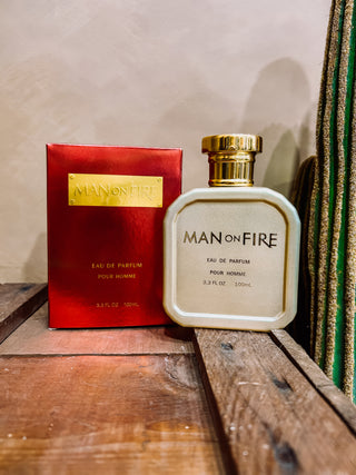Man on Fire perfume bottle and packaging on a wooden surface with a neutral background