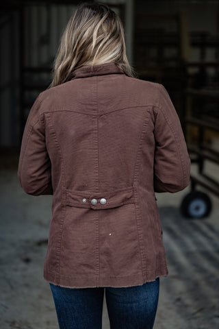 Person wearing a brown jacket in an indoor setting