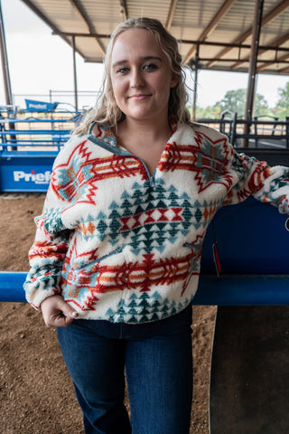 Woman wearing a patterned sweater in an indoor arena setting