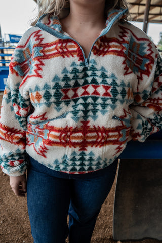 Person wearing a patterned pullover with a blurred background