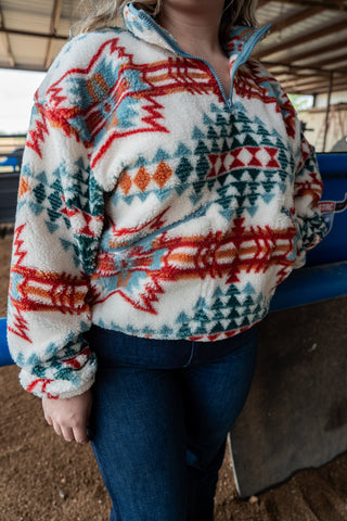 Person wearing a patterned fleece jacket with a blurred background