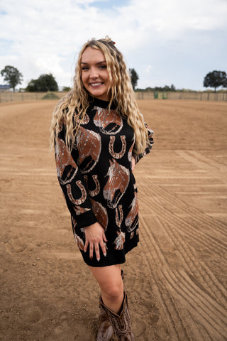 Woman wearing a black dress with horse patterns in an outdoor setting