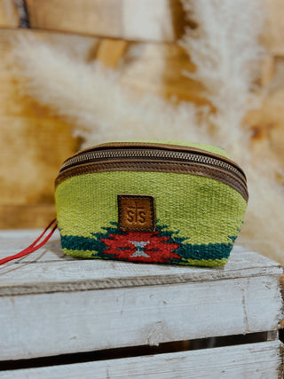 Small green pouch with a pattern and brown zipper on a wooden surface.