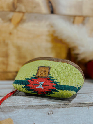 Small green textured pouch with a red and white design on a wooden surface
