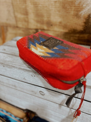 Red pouch with geometric pattern on a wooden surface