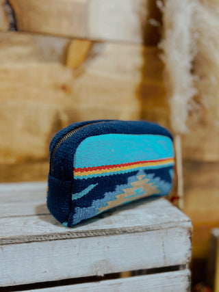 Small blue pouch with a colorful stripe on a wooden surface