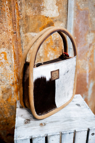 Handbag with a visible brand logo on a rustic wooden surface